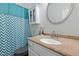 A bathroom with a large sink and mirror, and a shower and bath with a zigzag patterned curtain at 395 Timberlands Dr, Louisburg, NC 27549