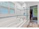 Bright bathroom with a soaking tub, a glass shower, and a view into the walk-in closet at 395 Timberlands Dr, Louisburg, NC 27549