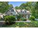 Charming two-story home featuring a stone facade, inviting front porch, and lush landscaping at 395 Timberlands Dr, Louisburg, NC 27549