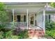 Inviting front porch with brick steps, white railings, and charming decorative lighting at 395 Timberlands Dr, Louisburg, NC 27549