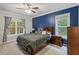 Serene main bedroom featuring a dark accent wall, large windows, and carpet flooring at 395 Timberlands Dr, Louisburg, NC 27549