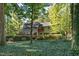Rear exterior of home featuring a deck surrounded by mature trees and landscaping at 403 Rutherglen Dr, Cary, NC 27511
