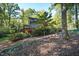 Rear exterior of home featuring a deck surrounded by mature trees and landscaping at 403 Rutherglen Dr, Cary, NC 27511