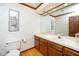 A powder room with a vanity, sink, mirror, decorative wallpaper and toilet at 403 Rutherglen Dr, Cary, NC 27511
