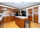 A kitchen featuring wood cabinets, stainless steel appliances, a center island, and hardwood floors at 403 Rutherglen Dr, Cary, NC 27511