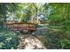 Charming wooden bridge crossing a creek with lush green ivy and beautiful trees in the background at 403 Rutherglen Dr, Cary, NC 27511
