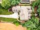 Aerial view of a home with a putting green, back deck, manicured lawn, and long driveway in a private wooded setting at 410 Mountain Laurel, Chapel Hill, NC 27517