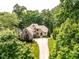 Aerial shot of a luxury home featuring beautiful landscaping and surrounding mature trees at 410 Mountain Laurel, Chapel Hill, NC 27517