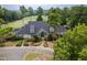 Exterior view of the clubhouse with a dark grey roof, landscaping, and trees at 410 Mountain Laurel, Chapel Hill, NC 27517