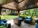 Shaded outdoor gazebo with comfortable seating, landscaping and a pathway to the home at 410 Mountain Laurel, Chapel Hill, NC 27517