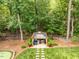 View of the gazebo featuring blue cushions, a table, and decor set amongst the trees at 410 Mountain Laurel, Chapel Hill, NC 27517