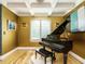 Elegant piano room with a grand piano, unique artwork and natural light from a large window at 410 Mountain Laurel, Chapel Hill, NC 27517
