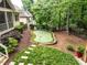 The home's backyard has a putting green, stone paver pathway, and mature trees for privacy at 410 Mountain Laurel, Chapel Hill, NC 27517