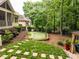 Backyard including the putting green, gazebo, stone paver pathway, and landscaped areas at 410 Mountain Laurel, Chapel Hill, NC 27517