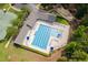 Aerial view of a swimming pool, showcasing community amenities with tennis courts, playground and trees at 410 Mountain Laurel, Chapel Hill, NC 27517