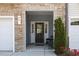 Inviting entryway with a stone facade, seating, and decorative plants at 44 Bordeaux Dr, Clayton, NC 27527