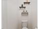 Clean bathroom showcasing a toilet with floating shelves and decorative accents for storage and style at 44 Bordeaux Dr, Clayton, NC 27527