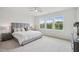 Spacious bedroom with neutral carpet, large bed, and three bright windows at 4502 Mint Leaf Lane Ln, Raleigh, NC 27612
