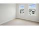 Bright bedroom with neutral carpet, white walls, and two large windows at 4502 Mint Leaf Lane Ln, Raleigh, NC 27612