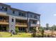 View of the home's rear exterior featuring wooden balconies, gray siding, and landscaping at 4502 Mint Leaf Lane Ln, Raleigh, NC 27612