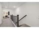 Bright hallway with carpet flooring, wood banister, and view of a bedroom in the background at 5000 Reader Way, Durham, NC 27703