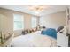 A bright bedroom features two windows, a ceiling fan, a bed, and an off-white walls and carpet at 508 E Hatterleigh Ave, Hillsborough, NC 27278