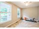 A bedroom featuring two bright windows, light neutral walls and carpet, and a ceiling fan at 508 E Hatterleigh Ave, Hillsborough, NC 27278
