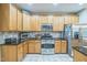 Well-lit kitchen with stainless steel appliances and ample cabinet space for storage at 508 E Hatterleigh Ave, Hillsborough, NC 27278