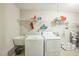 A bright laundry room featuring a utility sink and a white washer and dryer at 508 E Hatterleigh Ave, Hillsborough, NC 27278