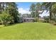 Spacious backyard with lush green grass, mature trees, and a covered patio at 509 Forest Ridge Rd, Garner, NC 27529