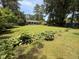 Sprawling backyard featuring lush greenery, mature trees, and colorful flowers at 509 Forest Ridge Rd, Garner, NC 27529