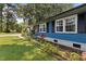 Side view of a blue home featuring vibrant landscaping with flowers and greenery at 509 Forest Ridge Rd, Garner, NC 27529