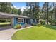 View of the home's exterior showing the blue siding, carport, lawn and landscaping at 509 Forest Ridge Rd, Garner, NC 27529