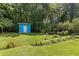 Blue and white outdoor shed surrounded by lush greenery and landscaping at 509 Forest Ridge Rd, Garner, NC 27529