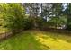 The spacious backyard is mostly lawn with mature trees surrounding the property at 518 S Coalport Dr, Apex, NC 27502