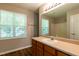 Bathroom showcasing large mirror, sink with cabinets, window and views to shower at 518 S Coalport Dr, Apex, NC 27502