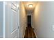 Hallway with wood floors that leads to multiple rooms and a doorway to the outside at 518 S Coalport Dr, Apex, NC 27502