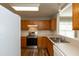 Bright kitchen features stainless steel appliances, wood cabinets, and a window to the dining area at 518 S Coalport Dr, Apex, NC 27502