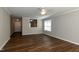 Bright living room featuring wood floors, ceiling fan, and view to entry and kitchen at 518 S Coalport Dr, Apex, NC 27502