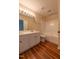Bathroom featuring dual sinks, a tub and shower combo, and wood style flooring at 5209 Echo Ridge Rd, Raleigh, NC 27612