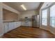 Bright kitchen featuring white cabinetry, stainless steel appliances, and durable laminate flooring at 5209 Echo Ridge Rd, Raleigh, NC 27612