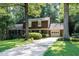 Traditional-style home features an attached garage and a concrete driveway nestled among mature trees at 5304 Cypress Ln, Raleigh, NC 27609