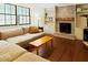 Living room with a fireplace, built-in shelving, hardwood floors, and a comfortable sectional sofa at 5304 Cypress Ln, Raleigh, NC 27609