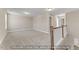 Spacious bonus room with neutral carpet, white trim and staircase with wood banister at 5504 Jaeger Dr # 76, Graham, NC 27253