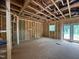 Framing of a room under construction, featuring exposed studs, windows, and a doorway leading outside at 5504 Jaeger Dr # 76, Graham, NC 27253