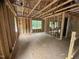Unfinished room with wood frame construction, sheathing, windows, and a plywood subfloor at 5504 Jaeger Dr # 76, Graham, NC 27253