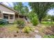 Inviting covered patio with brick stairs, mature trees, and decorative landscaping at 608 20Th St, Butner, NC 27509