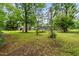 Spacious backyard with mature trees, lush lawn, and play area at 608 20Th St, Butner, NC 27509