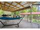 Relaxing covered deck features a hammock, seating, and views of the backyard at 608 20Th St, Butner, NC 27509