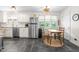 Sunlit kitchen boasts stainless steel appliances, white cabinets, and a quaint breakfast table at 608 20Th St, Butner, NC 27509